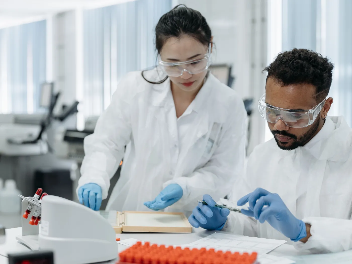 Two laboratory staff working with samples at a lab bench